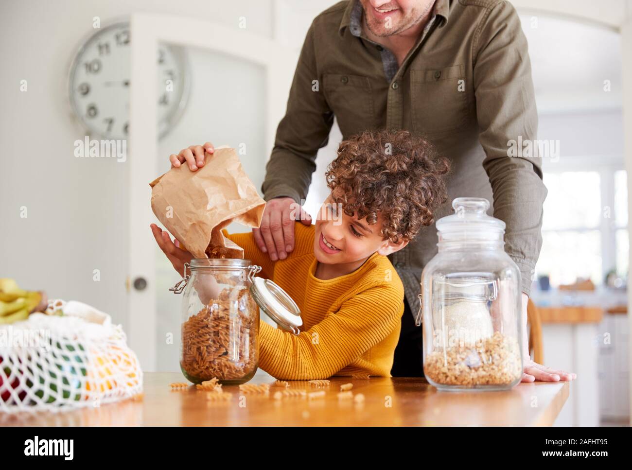 Vater hilft Sohn zum Nachfüllen für Lebensmittel zu Hause mit Null Verpackungsmüll Stockfoto