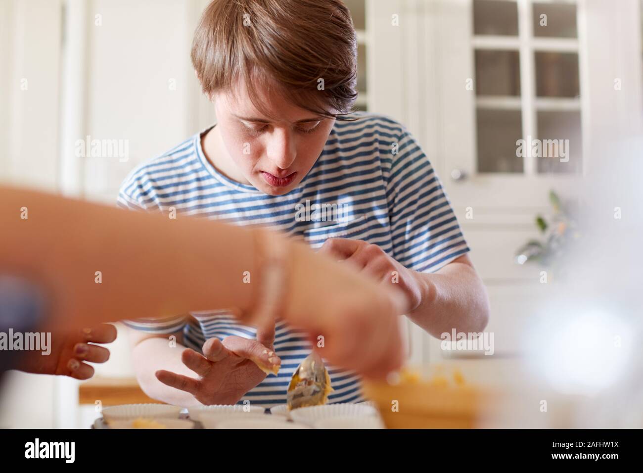 Junge Abstiegsyndrom paar Muffins backen in der Küche zu Hause. Stockfoto