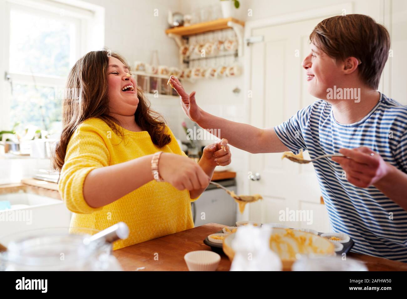 Junge Abstiegsyndrom Paar Spaß Baking Cupcakes in der Küche zu Hause. Stockfoto