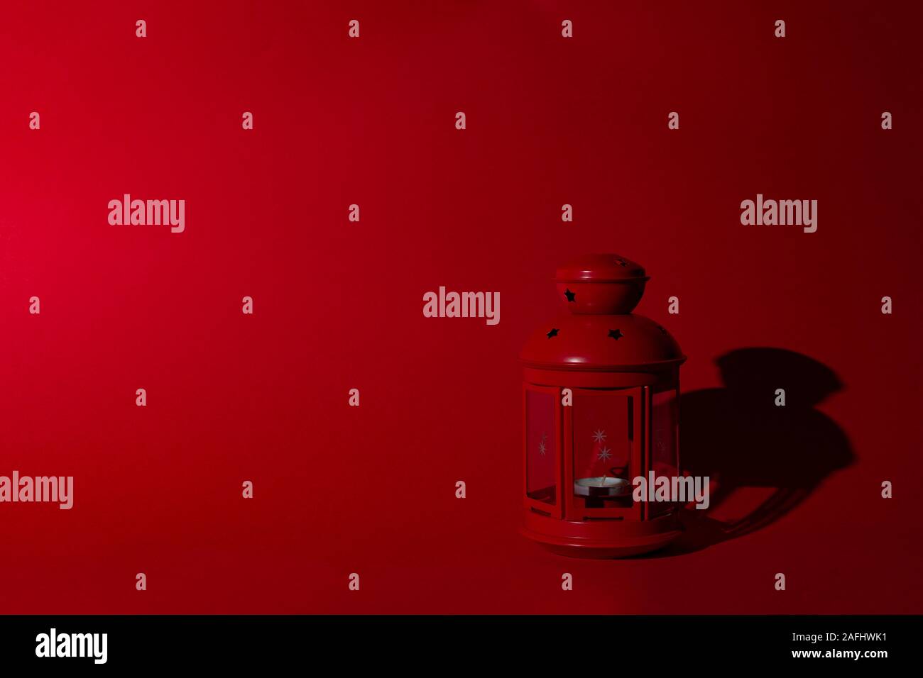 Red christmas Leuchter auf rotem Hintergrund in Form einer Straßenlaterne. Kopieren Sie Platz. Harte Schatten von harten Licht. Stockfoto