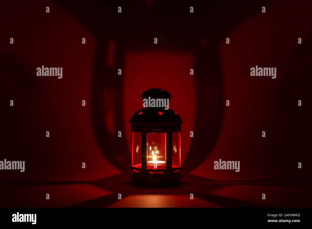 Red christmas Leuchter auf rotem Hintergrund in Form einer Straßenlaterne. Kopieren Sie Platz. Harte Schatten von harten Licht. Stockfoto