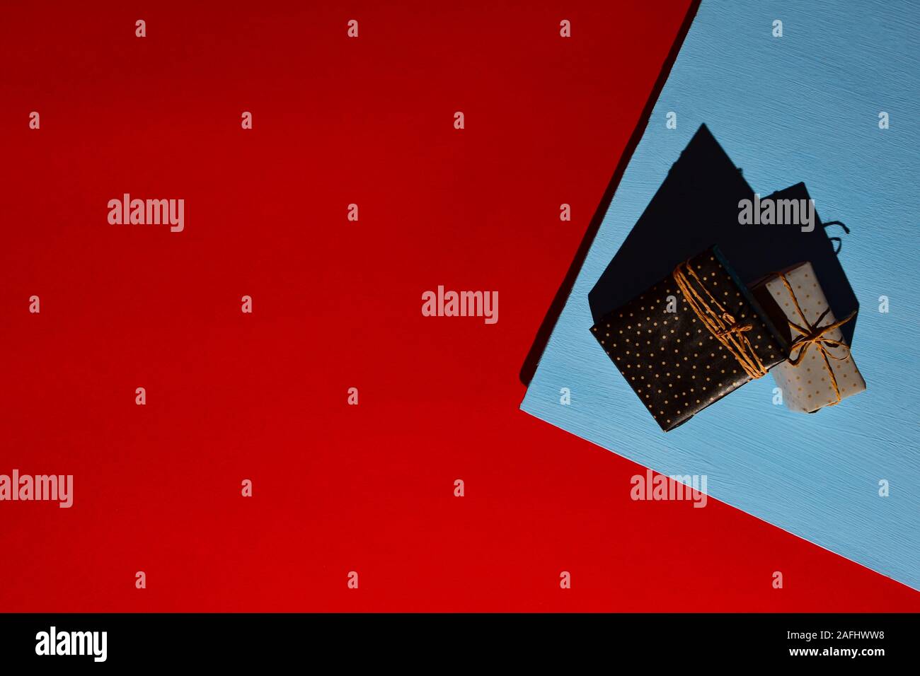 Geschenkboxen mit Handwerk Netzkabel auf zwei - Farbe blau roten Hintergrund gebunden. Harte Schatten von harten Licht. Für text Stockfoto