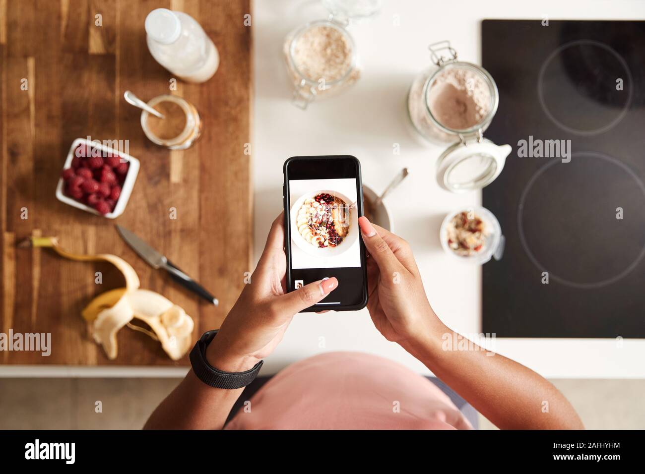 Overhead Shot der Frau unter Bild des gesunden Frühstück auf Handy zu Hause nach dem Training Stockfoto