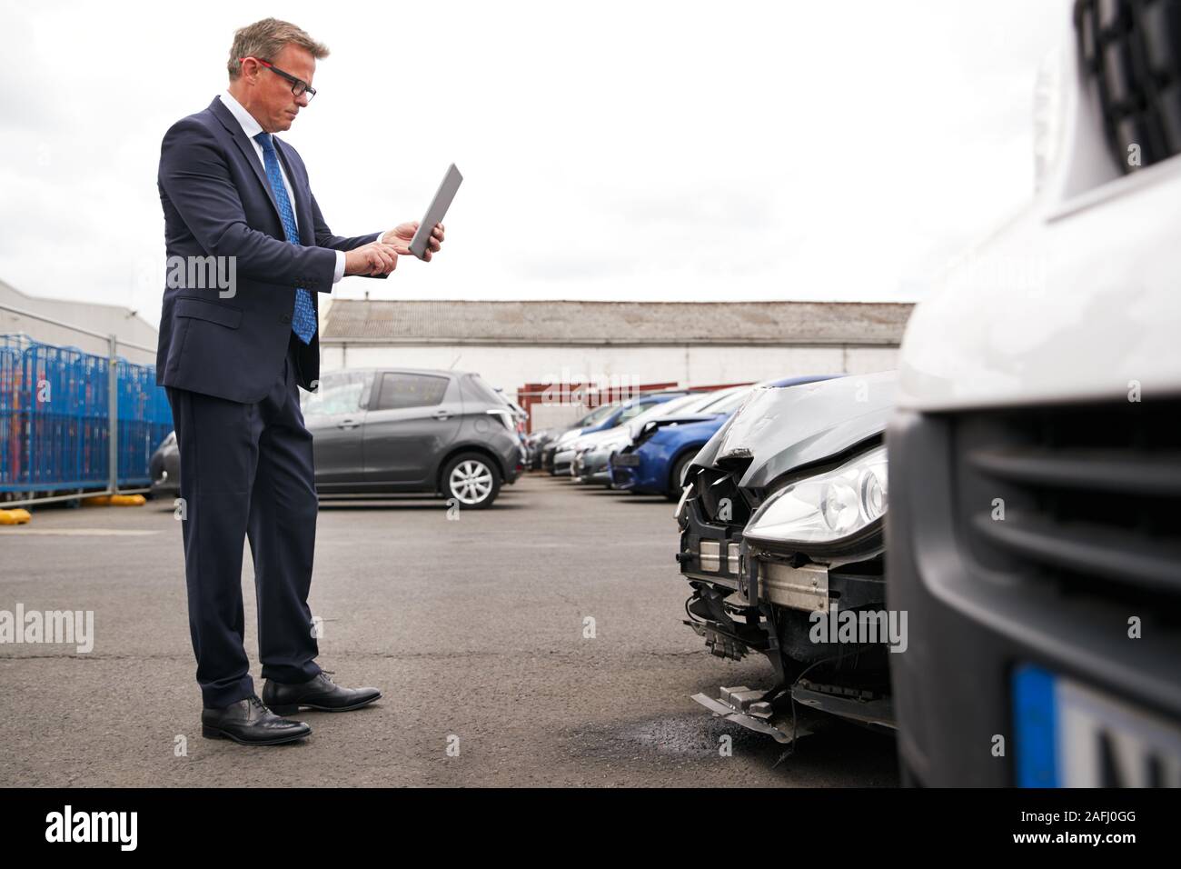 Versicherungen Loss Adjuster mit digitalen Tablet von Schäden an dem Auto von Motor Unfall Stockfoto