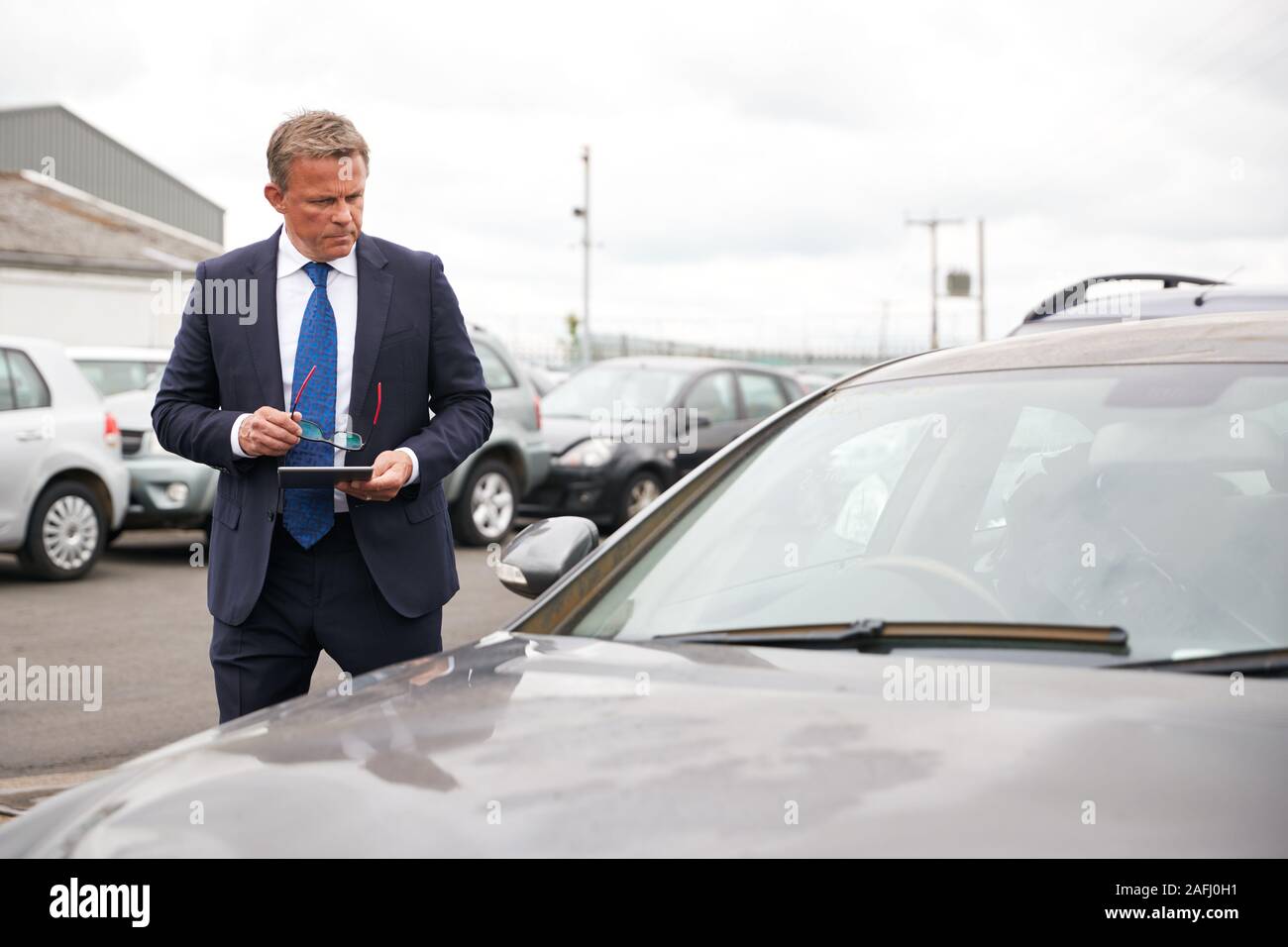Männliche Insurance Loss Adjuster mit digitalen Tablet Inspektion Schaden an dem Auto von Motor Unfall Stockfoto