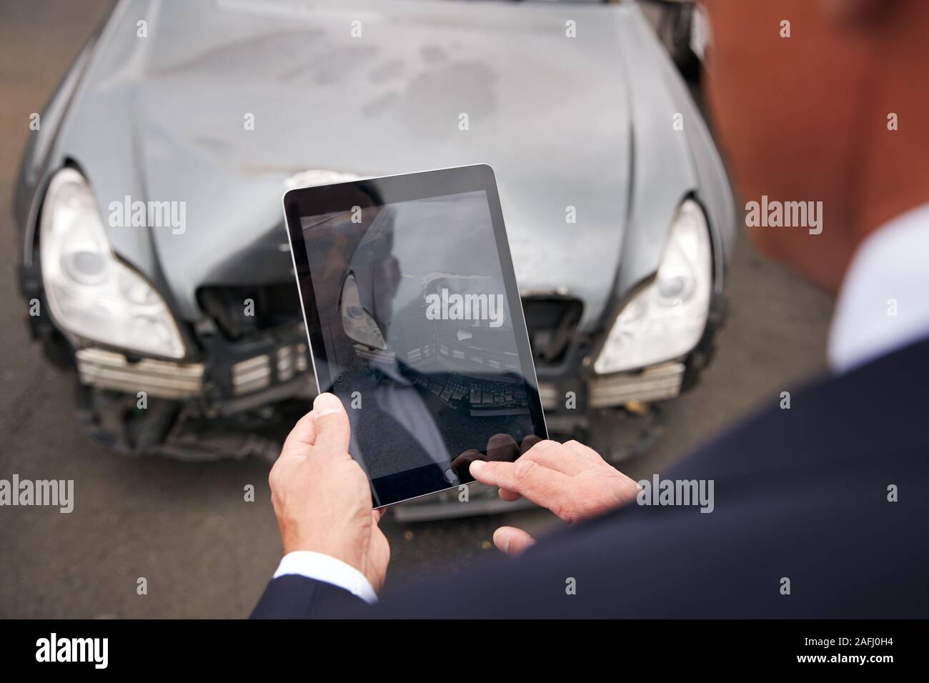 Versicherungen Loss Adjuster mit digitalen Tablet von Schäden an dem Auto von Motor Unfall Stockfoto