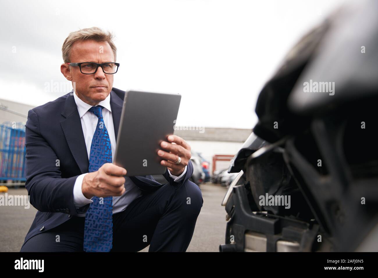 Versicherungen Loss Adjuster mit digitalen Tablet von Schäden an dem Auto von Motor Unfall Stockfoto