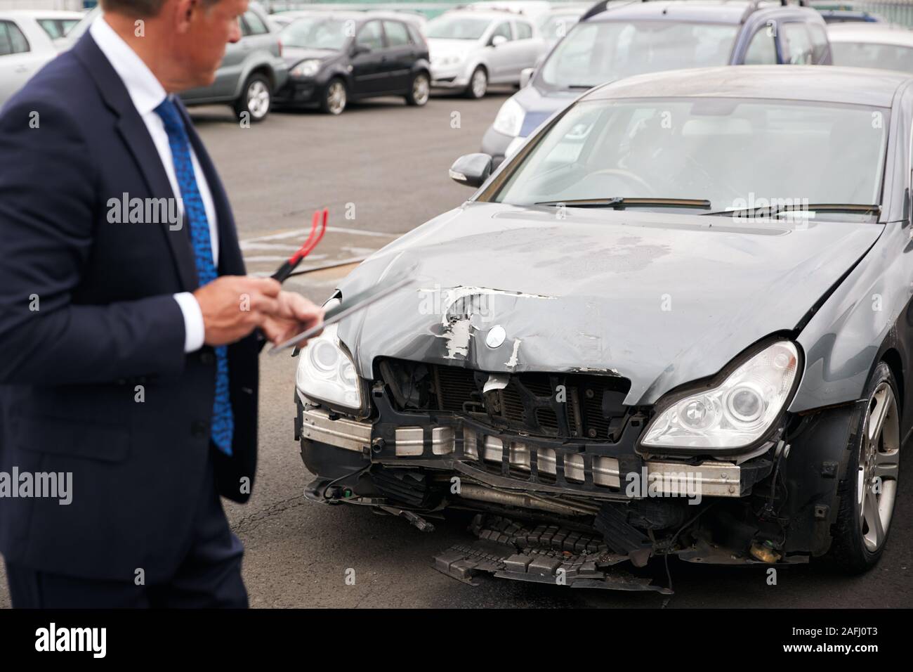 Männliche Insurance Loss Adjuster mit digitalen Tablet Inspektion Schaden an dem Auto von Motor Unfall Stockfoto