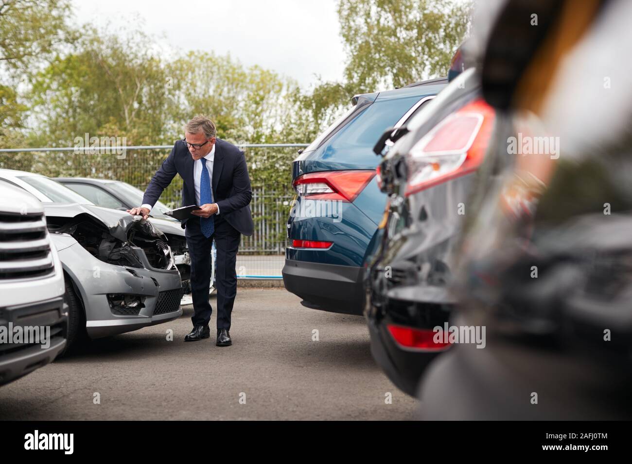 Männliche Insurance Loss Adjuster mit digitalen Tablet Inspektion Schaden an dem Auto von Motor Unfall Stockfoto