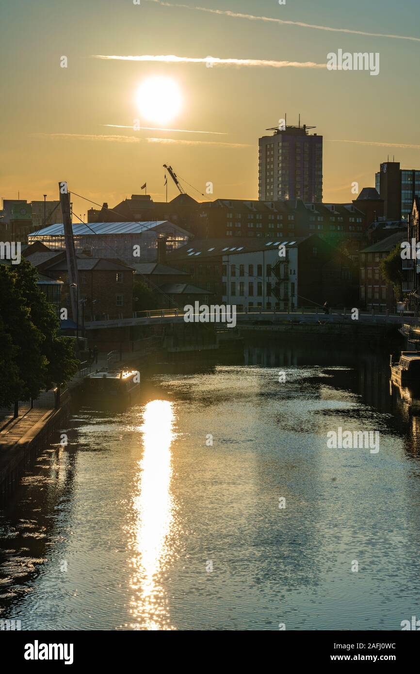 LEEDS, Großbritannien - 13 August: Blick auf den Sonnenuntergang über der Stadt am Fluss Gebäude entlang des Flusses Aire am 13. August 2019 in Leeds Stockfoto