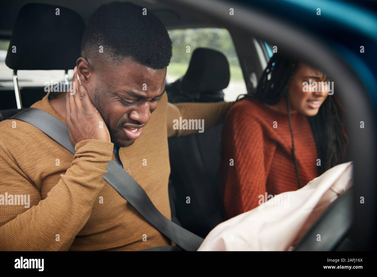 Paar In Car Crash mit männlichen Fahrer Leiden mit Schleudertrauma beteiligt Stockfoto
