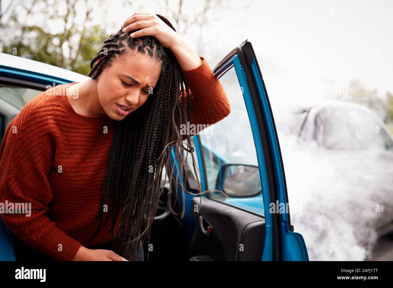 Weibliche Kraftfahrer mit Kopfverletzung Aussteigen aus dem Auto nach einem Crash Stockfoto