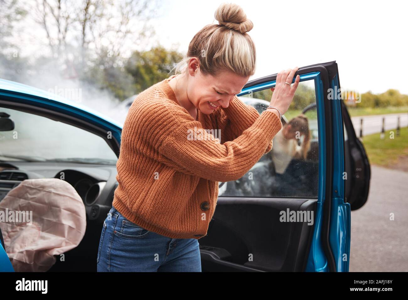 Weibliche Autofahrer in Crash für Crash Versicherungsbetrug Aussteigen aus dem Auto Stockfoto