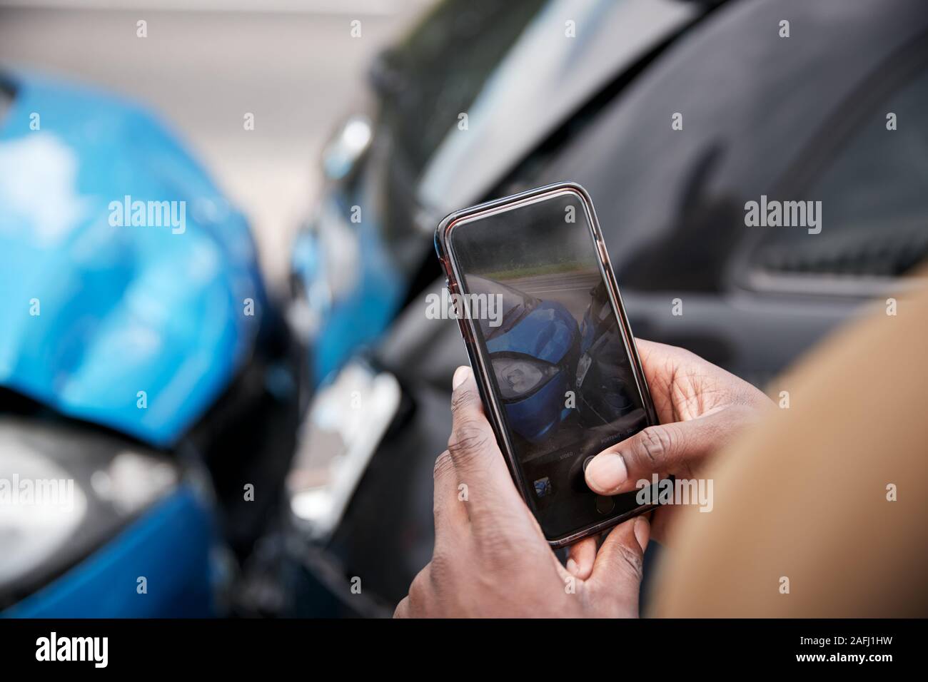 Männliche Autofahrer bei Autounfall, der Schaden für die Versicherung verwickelt Stockfoto