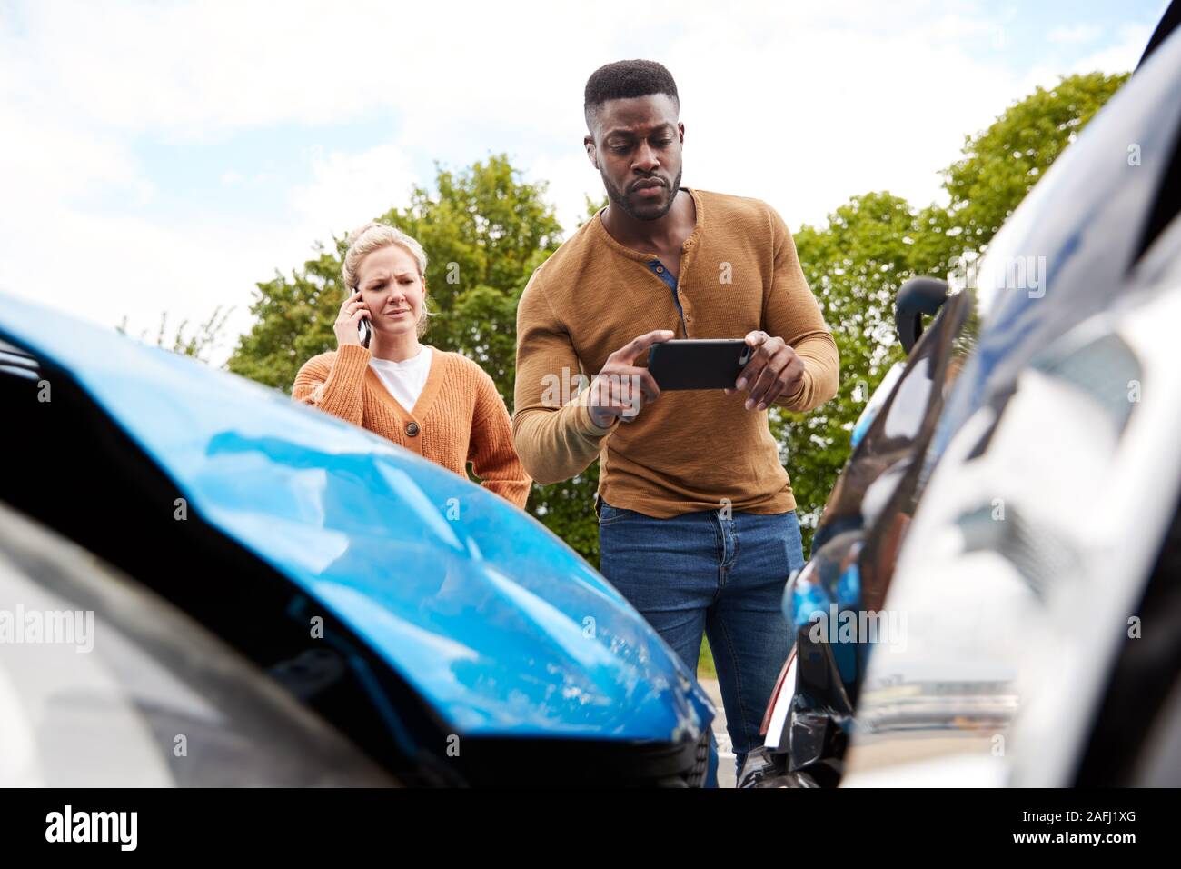 Männliche Autofahrer bei Autounfall, der Schaden für die Versicherung verwickelt Stockfoto