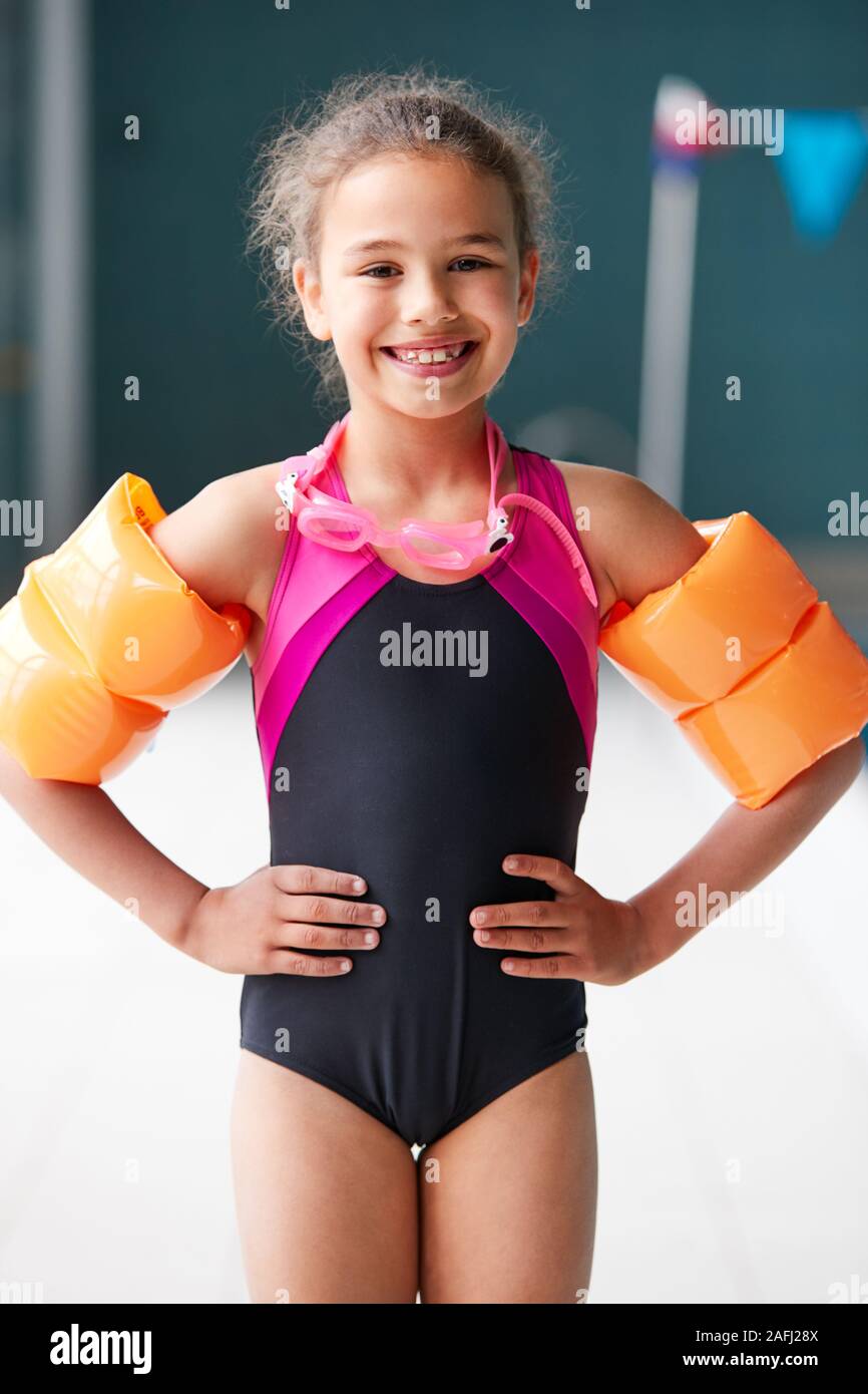 Portrait von Mädchen mit Armbinden stehen am Rande des Pools bereit für Lektion Stockfoto