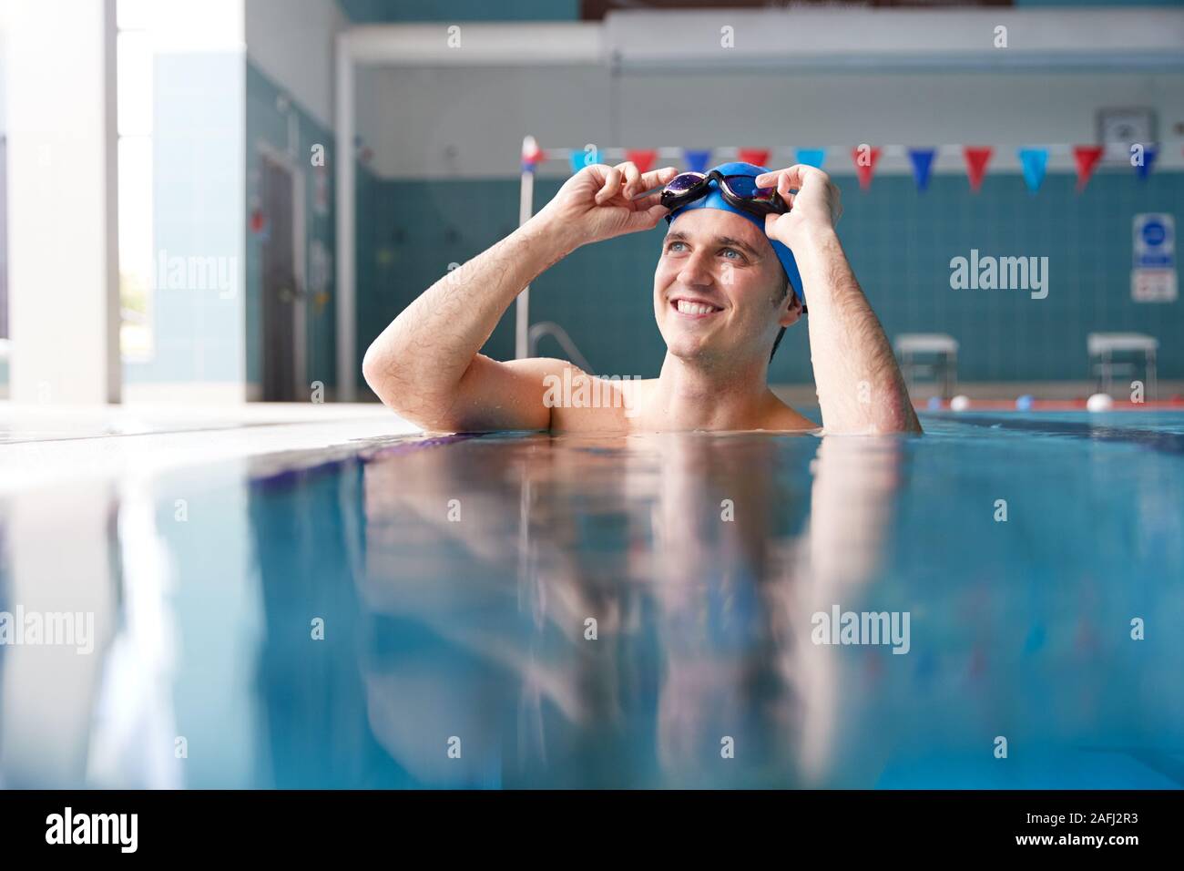 Männliche Schwimmer, Tragen, Hut und Brille Training im Schwimmbad Stockfoto