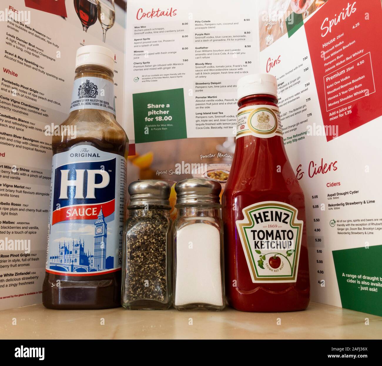 Gewürze - HP Sauce, Heinz Tomato Ketchup, Salz und Pfeffer - am Tisch im Restaurant. Großbritannien Stockfoto