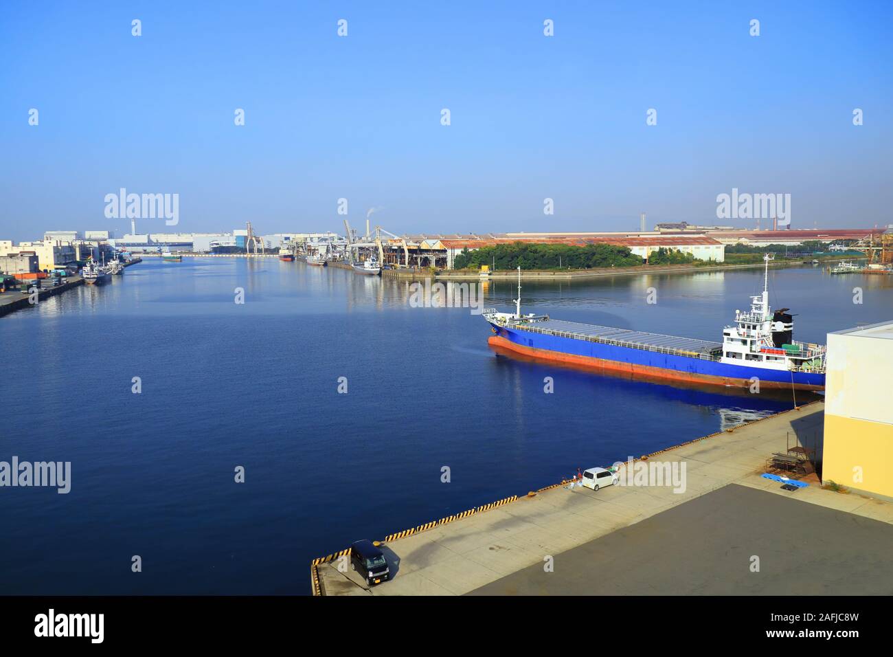 Ein Frachtraum Japan Küsten Schiff im Hafen von Fabrikhallen auf Osaka Bay, Japan umgeben ist. Stockfoto