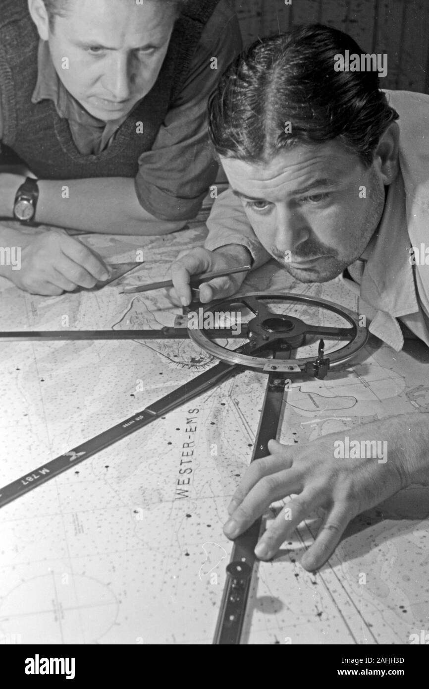 Navigare necesse Est - Der Navigator überprüft laufend die Position und die Fahrt des Schiffs vor dem Hafen von Emden, Niedersachsen, Deutschland 1950. Navigator Kontrolle der Position und die Art und Weise, wie das Schiff in der Nähe der Hafen von Emden, Niedersachsen, Deutschland 1950. Stockfoto