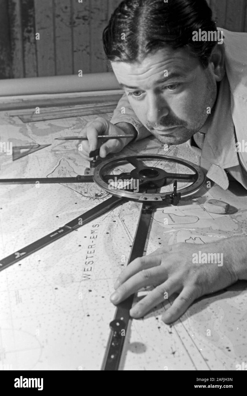 Navigare necesse Est - Der Navigator überprüft laufend die Position und die Fahrt des Schiffs vor dem Hafen von Emden, Niedersachsen, Deutschland 1950. Navigator Kontrolle der Position und die Art und Weise, wie das Schiff in der Nähe der Hafen von Emden, Niedersachsen, Deutschland 1950. Stockfoto