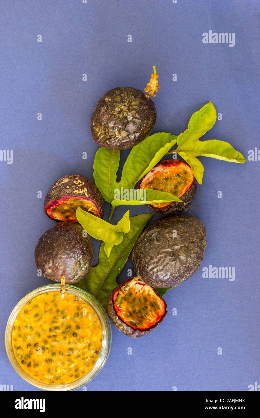 Flach legen Zusammensetzung mit Leidenschaft Fruchtfleisch, ganze Leidenschaft Obst, geschnitten Leidenschaft Früchte und Blätter von der Passionsfrucht Rebe Stockfoto