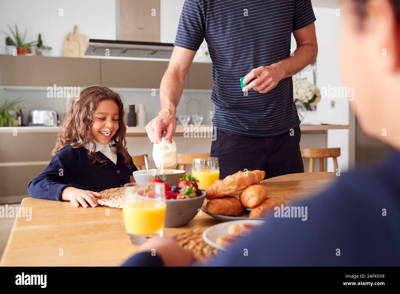 Vater in der Küche helfen, Kinder mit Frühstück, bevor Sie in die Schule gehen Stockfoto