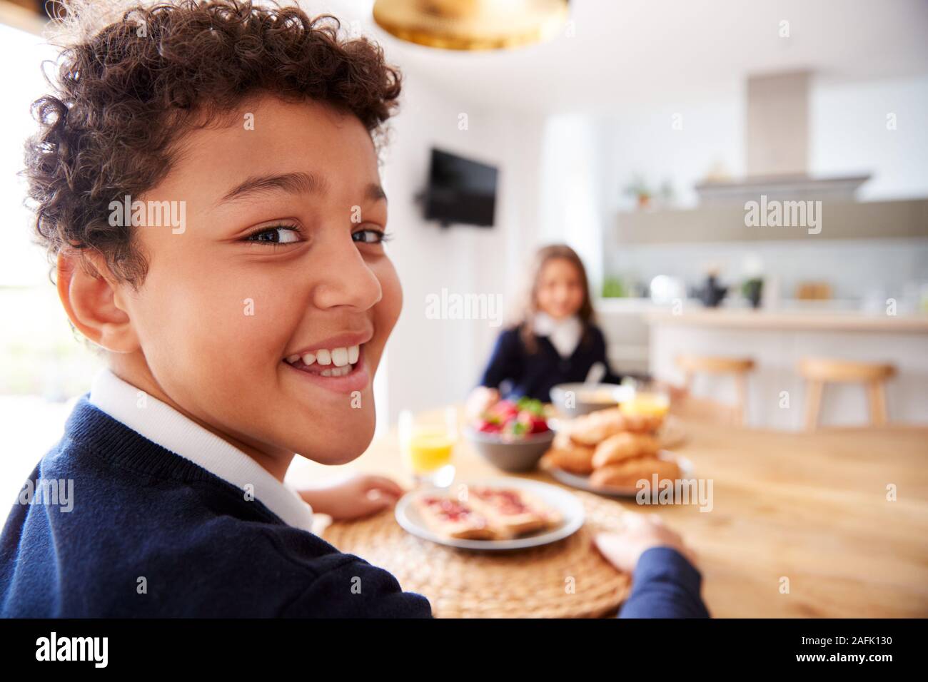 Portrait von Kindern tragen Uniform in der Küche Frühstücken, bevor sie in die Schule gehen Stockfoto