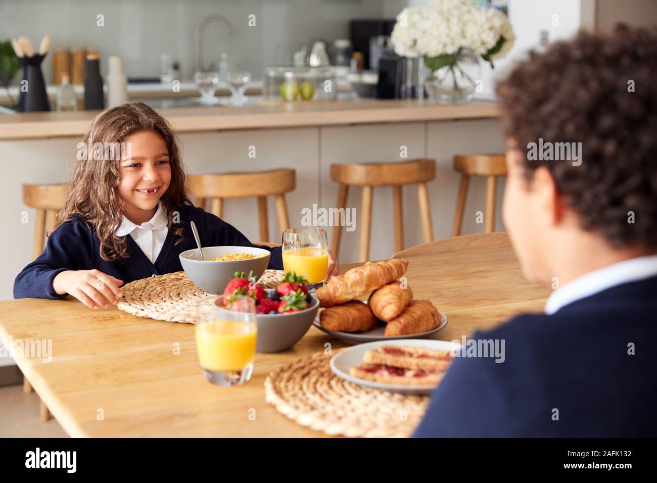 Kinder Uniform tragen In der Küche Frühstücken, bevor sie in die Schule gehen Stockfoto