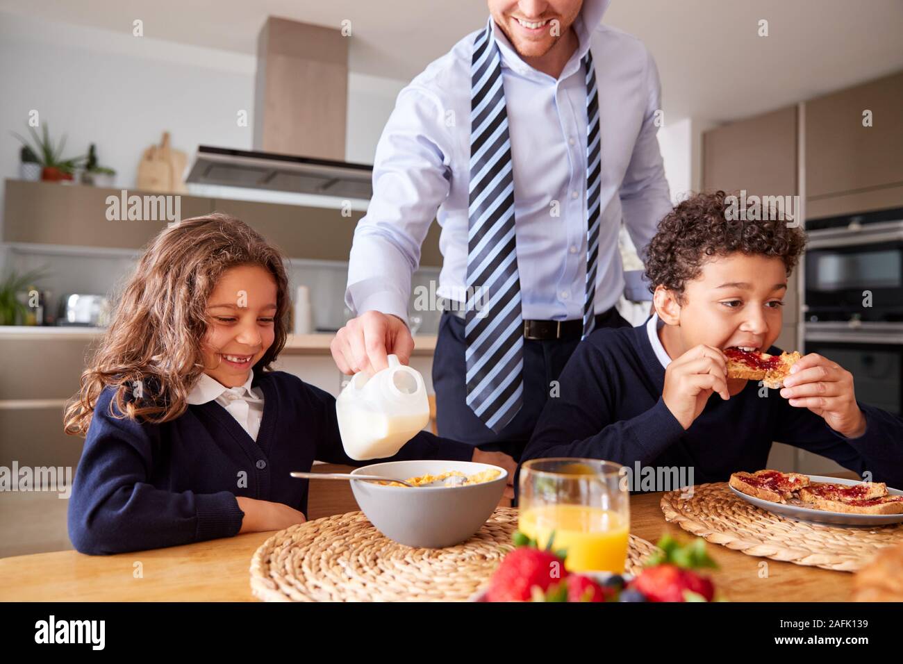 Geschäftsmann Vater in der Küche helfen, Kinder mit Frühstück, bevor Sie in die Schule gehen Stockfoto