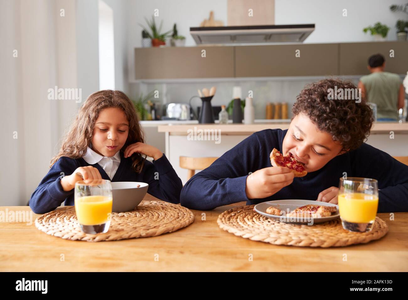 Kinder Uniform tragen In der Küche Frühstücken, bevor sie in die Schule gehen Stockfoto