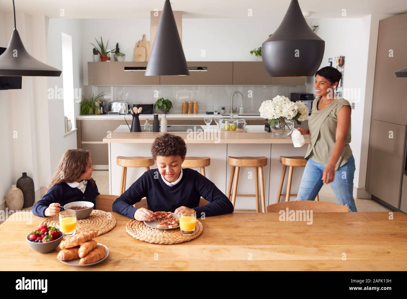 Mutter in der Küche helfen, Kinder mit Frühstück, bevor Sie in die Schule gehen Stockfoto