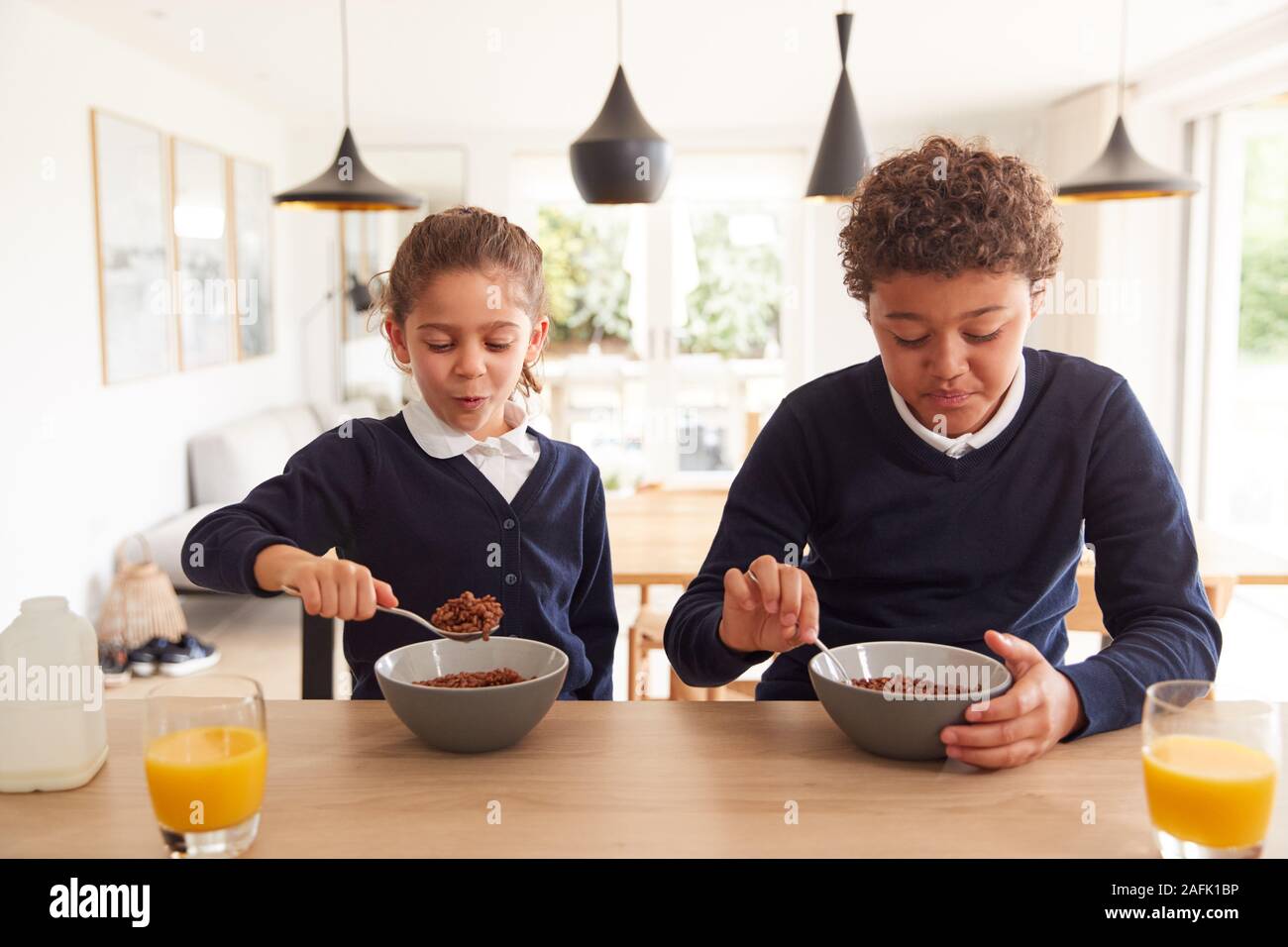 Kinder In der Küche Essen der zuckerhaltigen Frühstück, bevor Sie in die Schule gehen Stockfoto