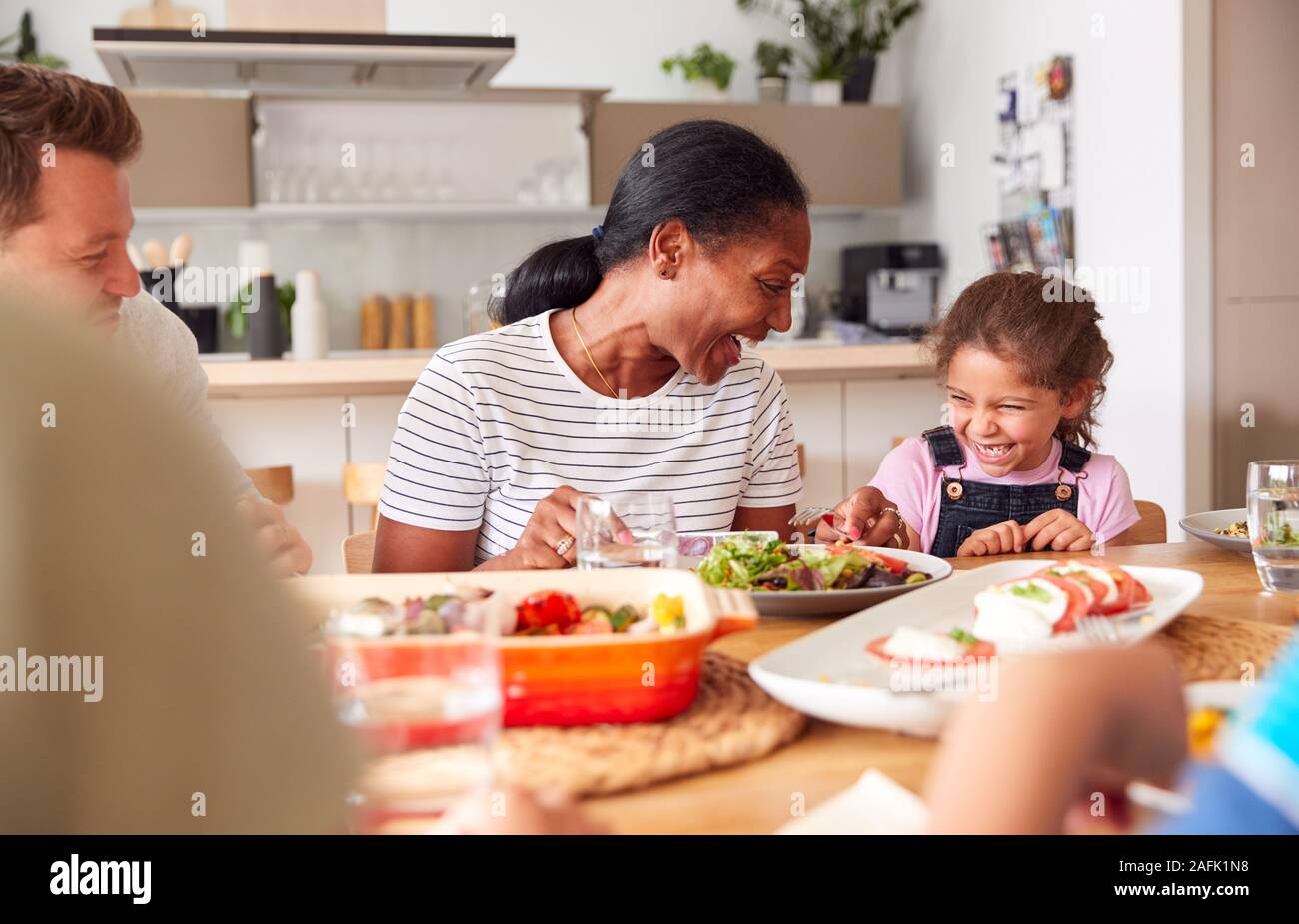 Multi-Generation gemischten Rennen Familie essen Essen um den Tisch zu Hause zusammen Stockfoto