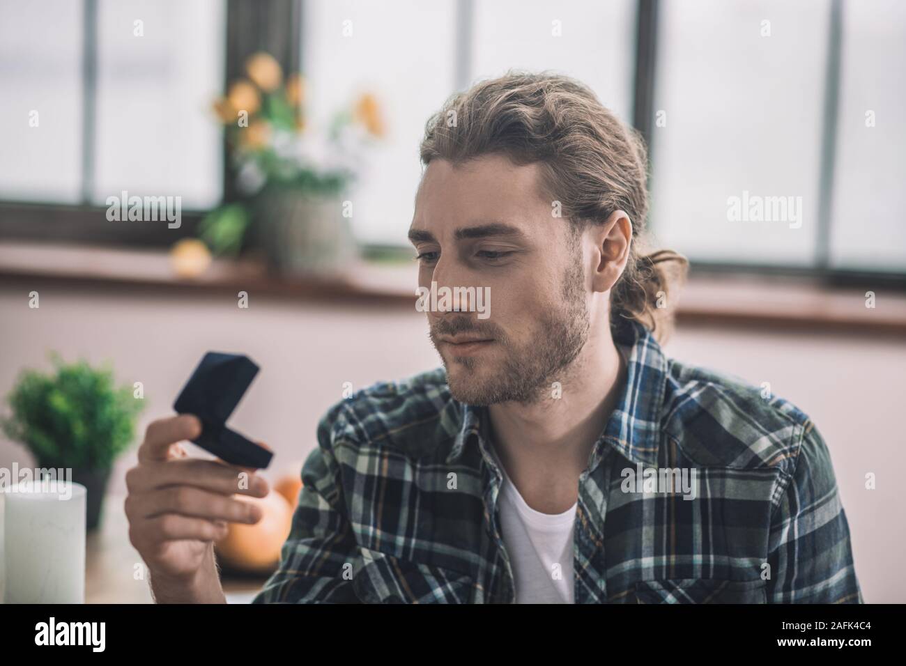 Nachdenklicher junger Mann sucht bei der Hochzeit Ring box Stockfoto