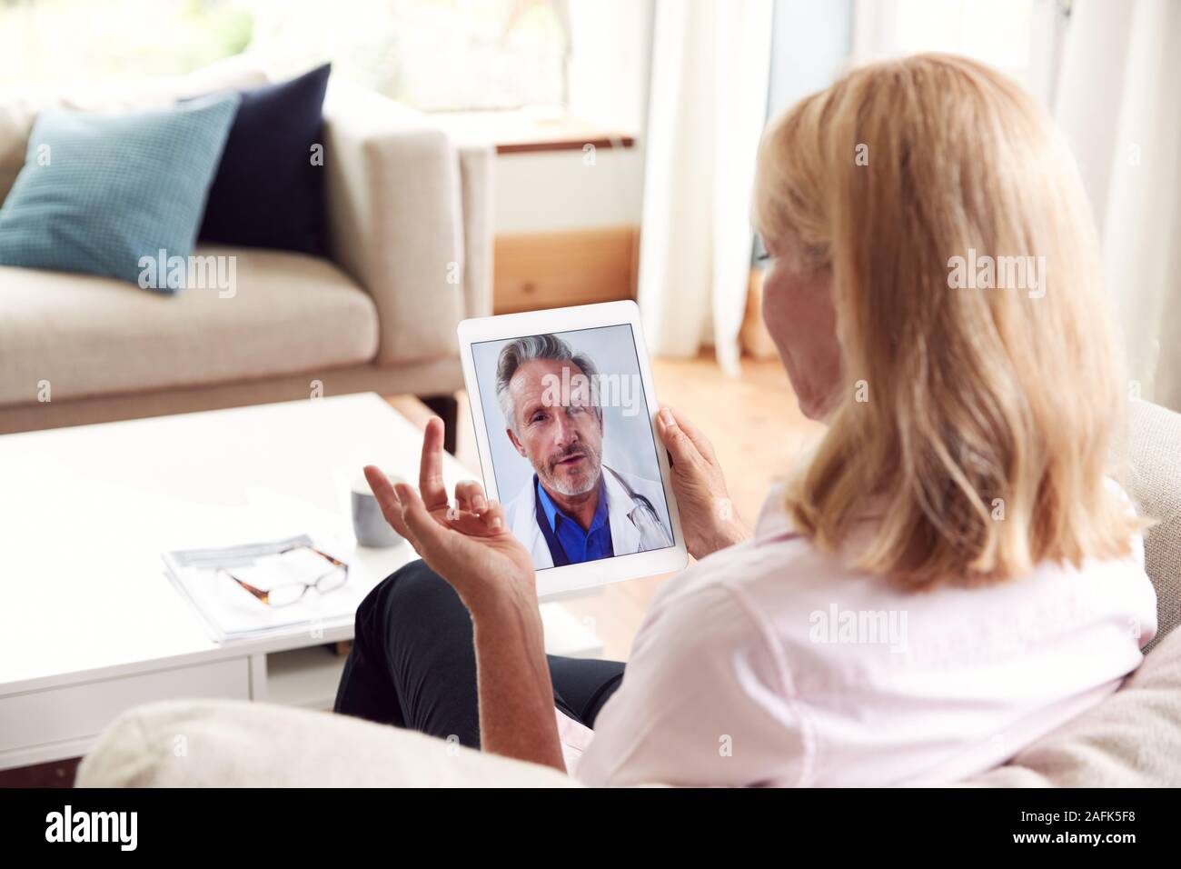 Reife Frau in On-line-Konsultation mit dem Arzt zu Hause auf Digital Tablet Stockfoto