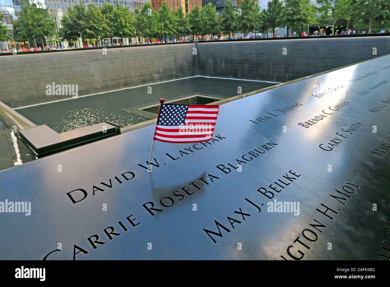 11. September - 0911 - National September 11 Memorial North Tower Fountain with USA Flag, One World Trade Center, Lower Manhattan, New York City, NY, USA Stockfoto