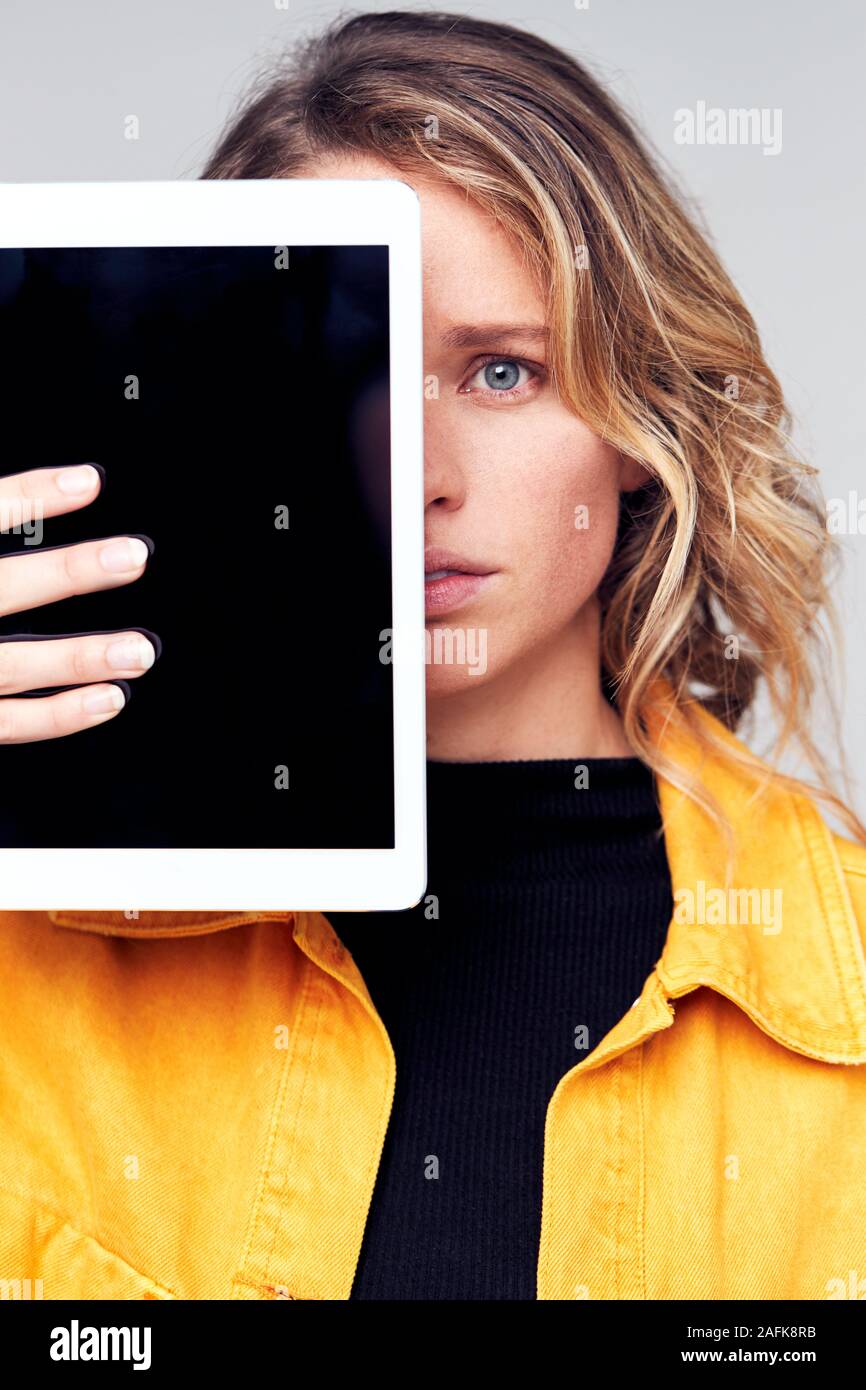 Studio Portrait von Sorgen junge Frau mit Gesicht mit digitalen Tablet Stockfoto