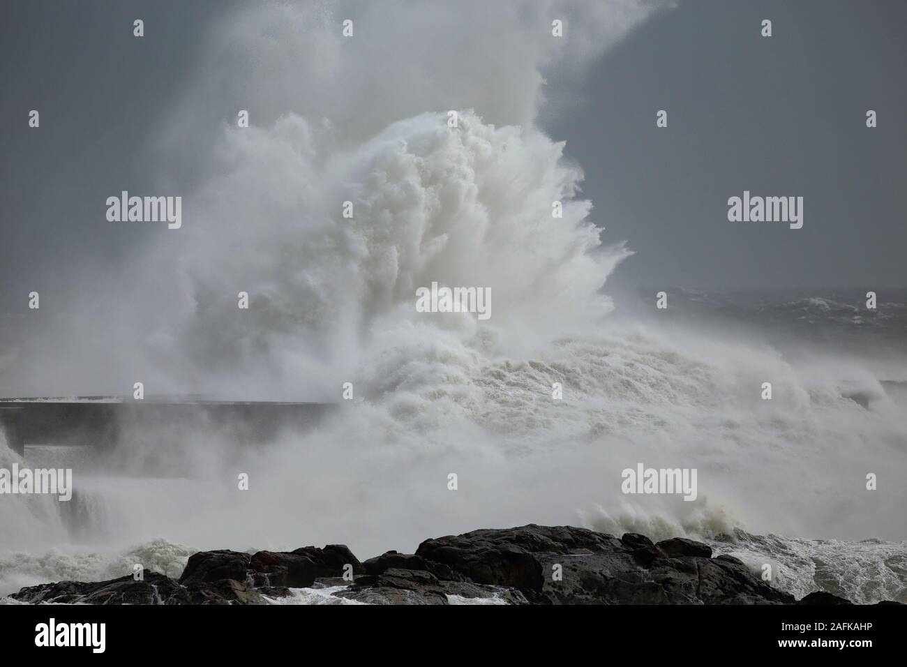 Stürmische Wellen planschen und wind Spray gegen ocean Pier aus dem Norden von Portugal. Stockfoto