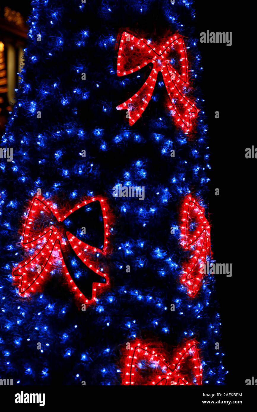 Teil von Christbaumschmuck blau blinken. Detail des Neuen Jahres string Reis Glühlampen Simulation Form der rote dekorative funkeln Bögen. Stockfoto