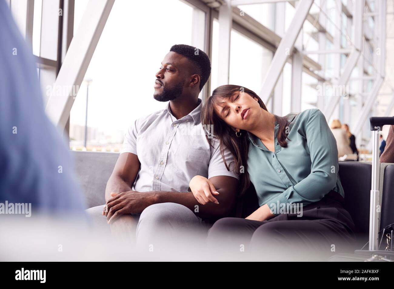 Müde Geschäft Paar durch Fenster Warten im Flughafen Abflughalle Stockfoto