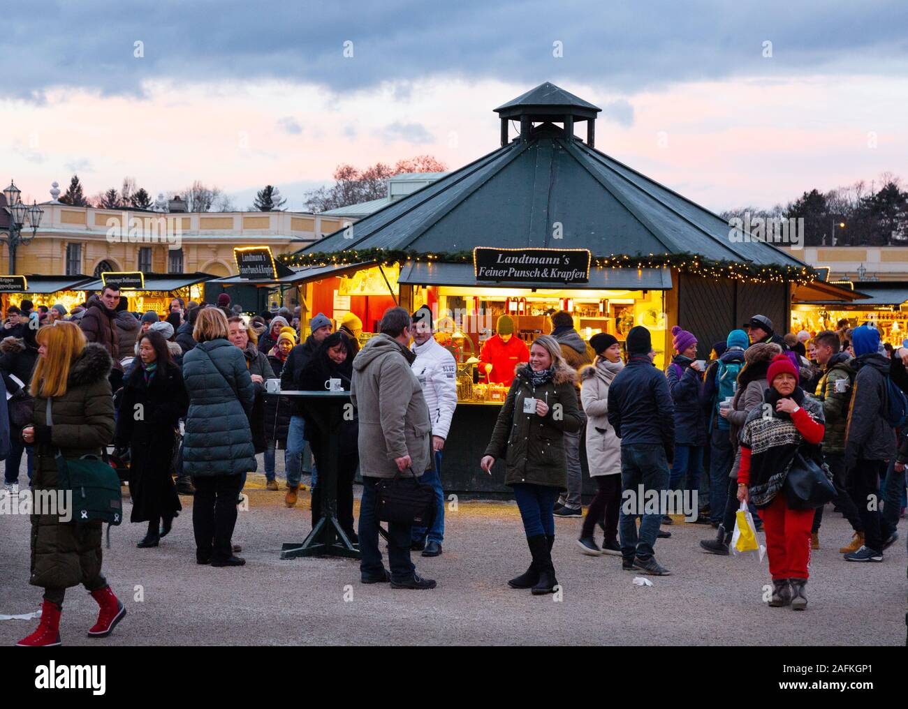 Menschen einkaufen und trinken Gluhwein bei Sonnenuntergang, auf dem Weihnachtsmarkt, Schloss Schönbrunn Wien Österreich Europa Stockfoto
