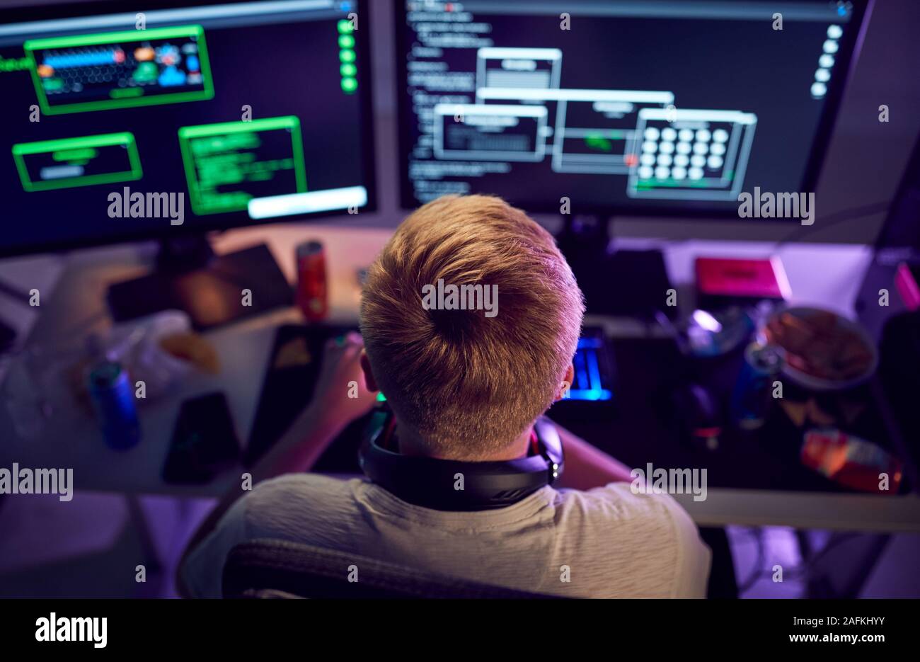 Männliche Jugendliche Hacker sitzen vor den Bildschirmen Umgehung Cyber Security Stockfoto