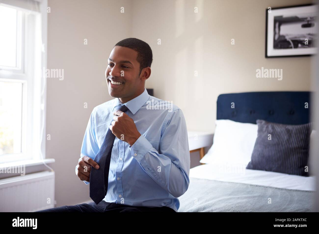 Junger Mann, gekleidet in Schlafzimmer für ersten Tag bei der Arbeit im Büro Stockfoto