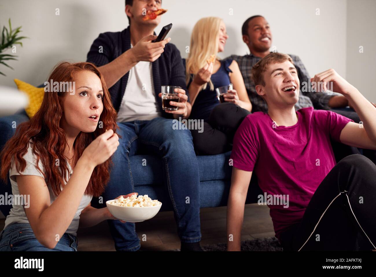 Gruppe Studenten im gemeinsamen Haus Fernsehen und Essen Popcorn Stockfoto