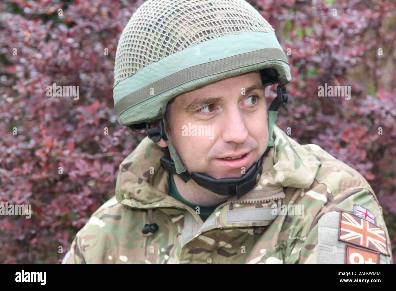 Britische Armee Soldat in der Armee Grüns camo Outfit, Jacke und Helm. Stockfoto
