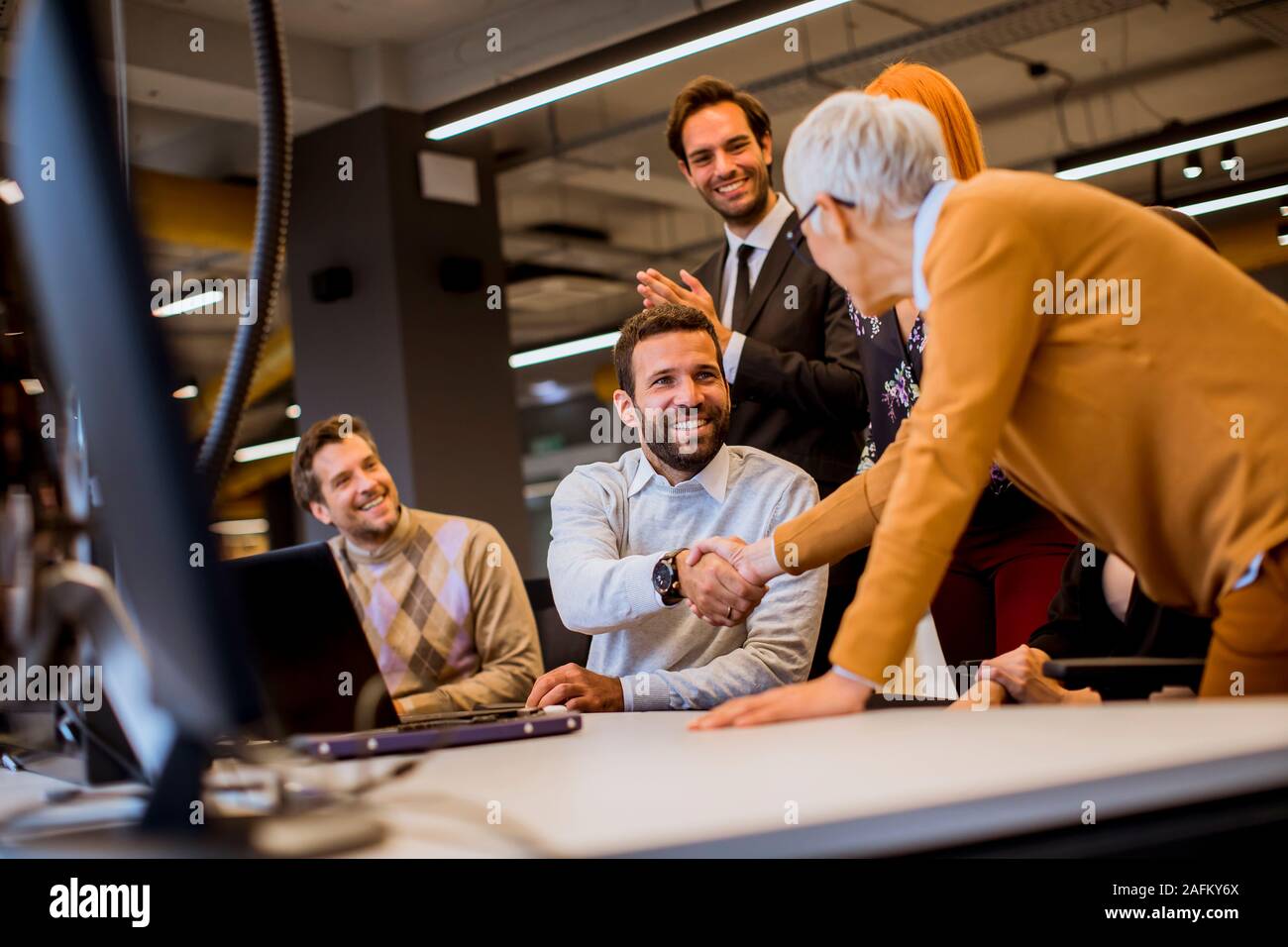 Senior Geschäftsfrau gemeinsam mit jungen Unternehmern im modernen Büro Stockfoto