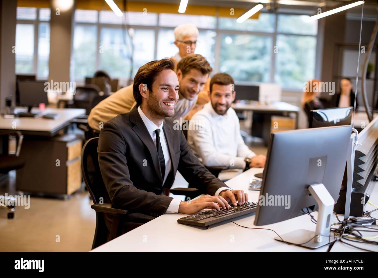 Senior Geschäftsfrau und junge Geschäftsleute arbeiten im modernen Büro Stockfoto
