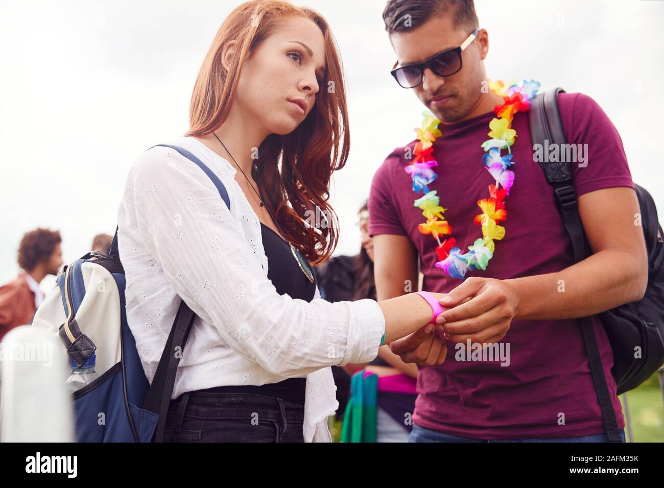 Gruppe von Freunden am Eingang der Music Festival setzen auf Sicherheit Armbänder Stockfoto