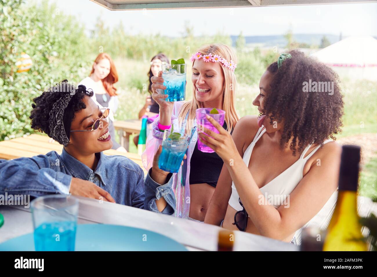 Weibliche Freunde kaufen Getränke in der Bar bei Musik Festival einen Toast Stockfoto